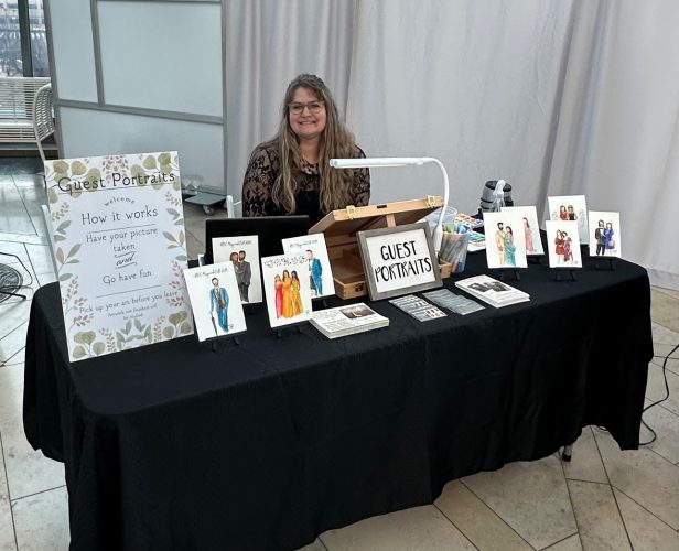 Artist Tracy Tauber at an event, ready to start painting Guest Portraits in 2024. She can paint live at your wedding-event, or from photographs after.